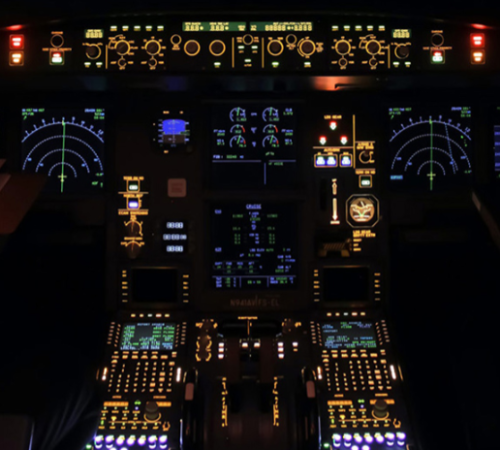 Aeroplane cockpit at night, showing the dials and flight instruments lit up